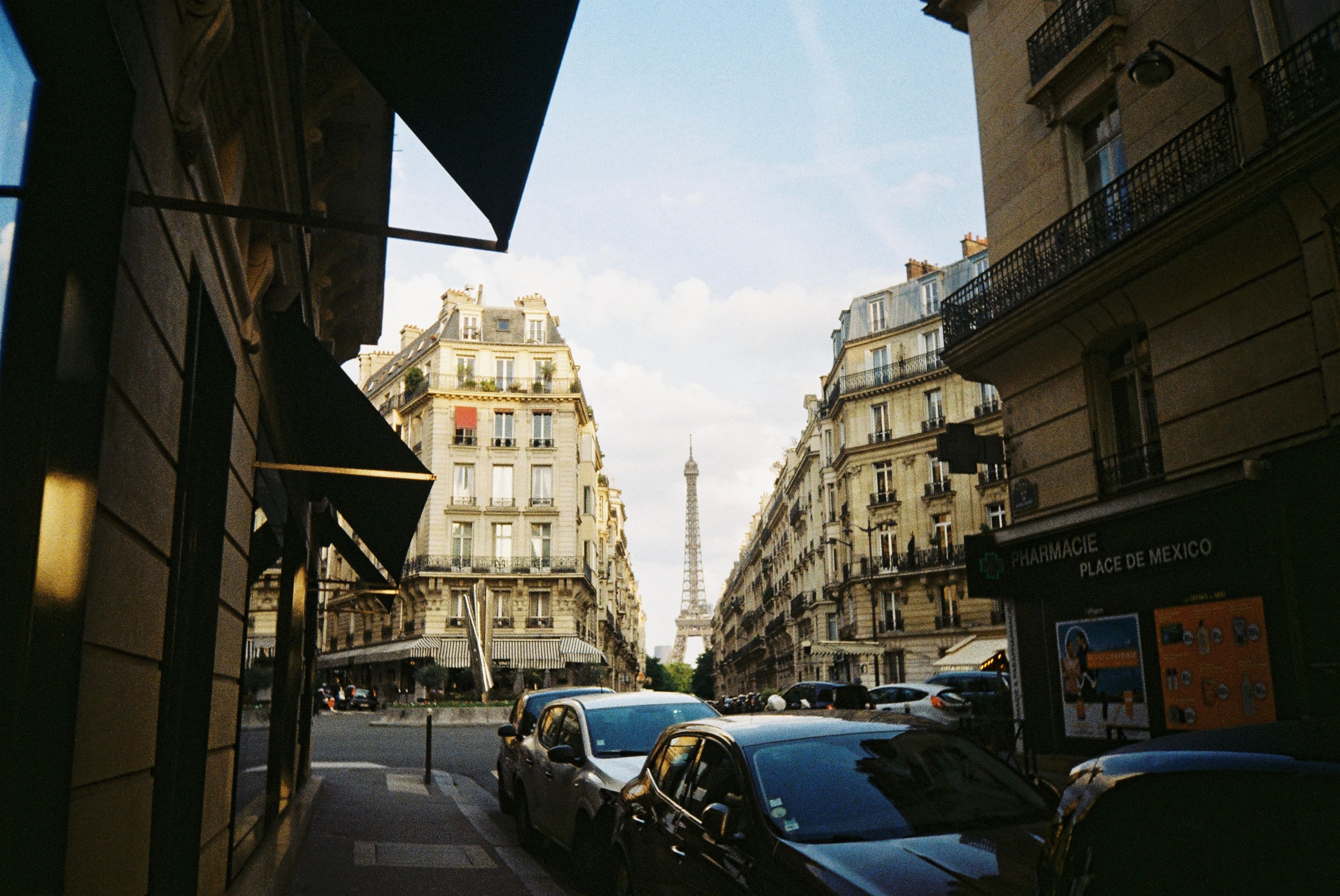 Paris cityscape featuring the Eiffel Tower framed by classic Haussmann buildings.
