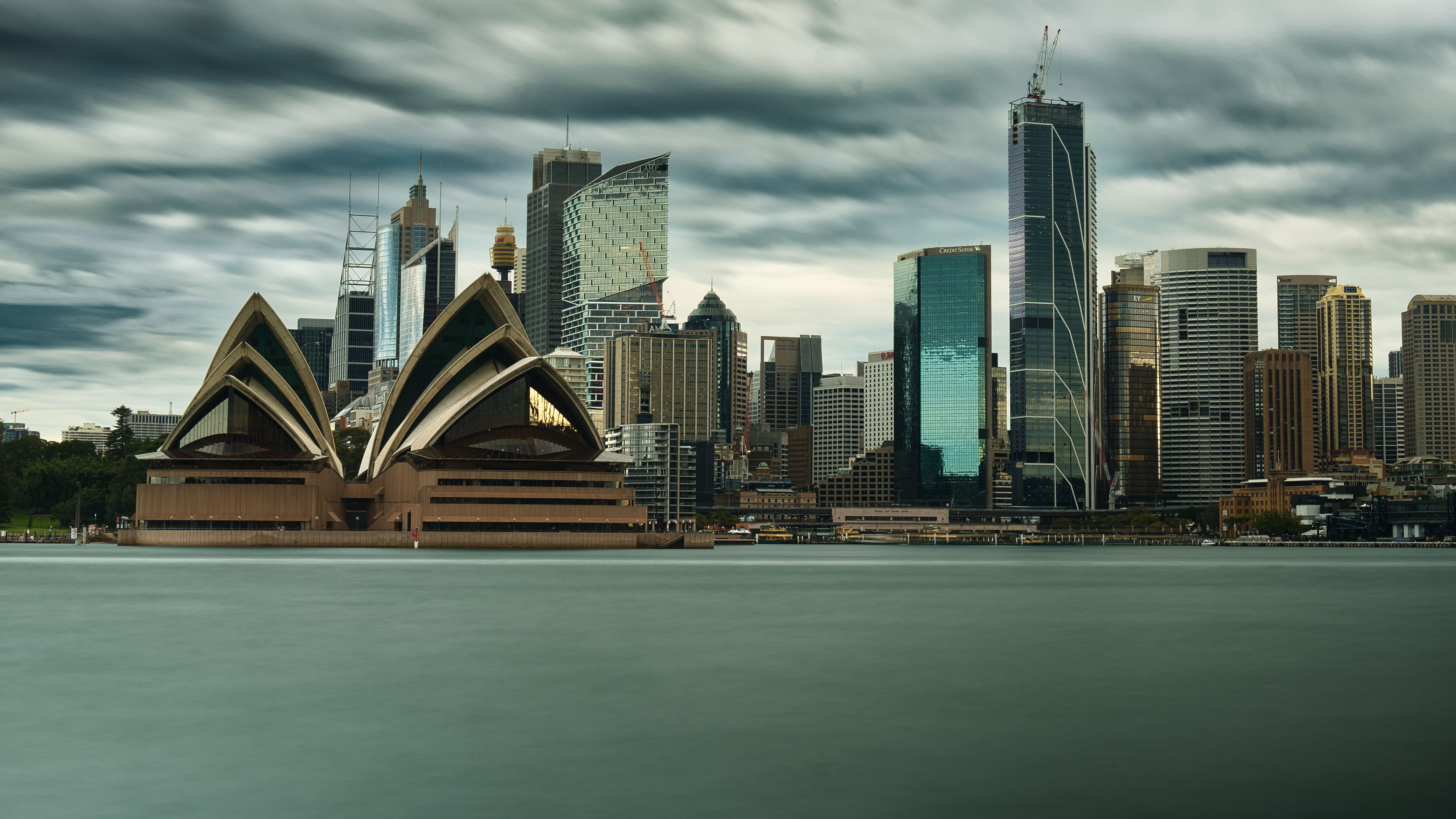 Panoramic Sydney skyline featuring the Opera House and harbor skyscrapers.
